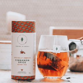 Teepackung neben Glas mit Tee