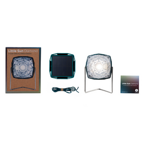 Verpackungsinhalt der Little Sun Diamond Solarlampe, bestehend aus der Box, dem Kabel, der Lampe und dem Heft. 