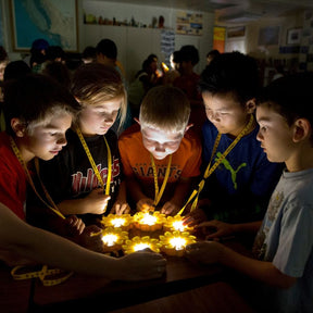 Eine Gruppe Schüler bewundern das Licht ihrer Little Sun Original Solarlampen.