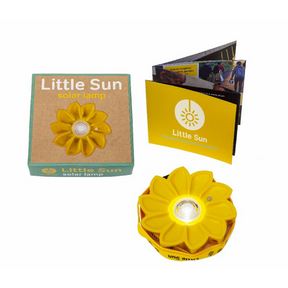 Verpackungsinhalt der Little Sun Original Solarlampe, bestehend aus einer Box, der Lampe mit Umhängeband und einem Heft. 
