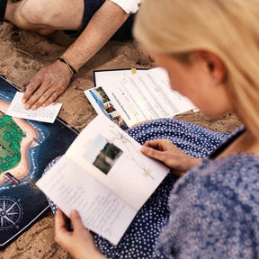 Frau ließt in dem Spielplan, Spiel ist im Hintergrund aufgebaut