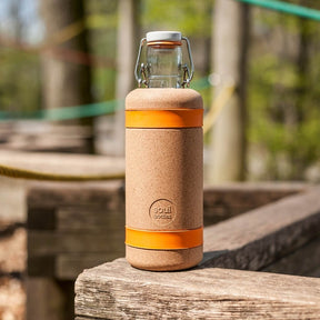 Soulsleeve orange mit Flasche drin steht in der Natur