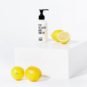 Handbalsam Lemon Honey neben Zitronen