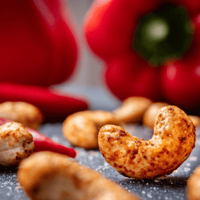 Feuertänzer Nüsse, im Hintergrund Paprika und Chili