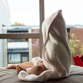 Baby im Handtuch schaut aus dem Fenster