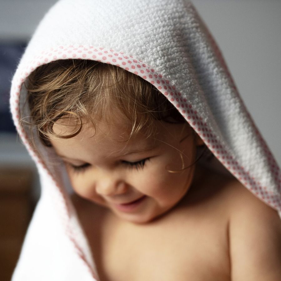 Lachendes Baby in Handtuch eingewickelt