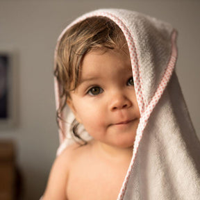 Baby im Handtuch schaut in die Kamera