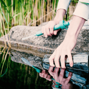 soulbottle Trinkflasche wird mit dem Filter im See aufgefüllt