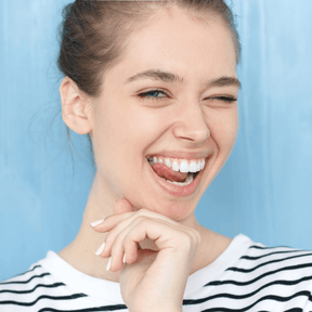 Frau zeigt ihr Zähne und zwinkert