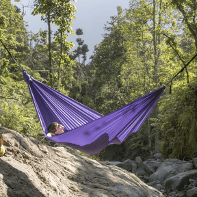 Frau liegt in der Natur in der Compact Hängematte